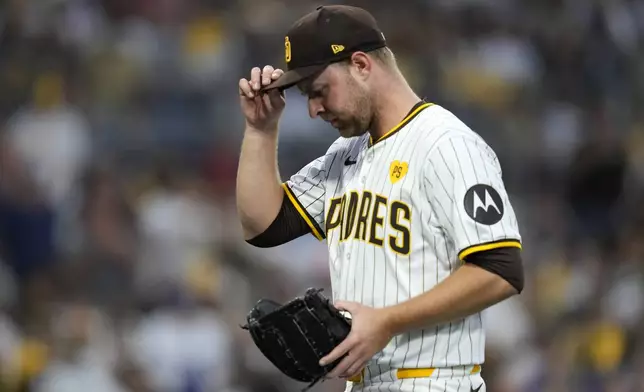 San Diego Padres pitcher Michael King adjusts his cap after giving up a solo home run to Los Angeles Dodgers' Mookie Betts during the first inning in Game 3 of a baseball NL Division Series Tuesday, Oct. 8, 2024, in San Diego. (AP Photo/Ashley Landis)