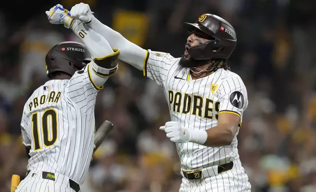 San Diego Padres' Fernando Tatis Jr., right, celebrates his two-run home run with Jurickson Profar during the second inning in Game 3 of a baseball NL Division Series against the Los Angeles Dodgers, Tuesday, Oct. 8, 2024, in San Diego. (AP Photo/Ashley Landis)