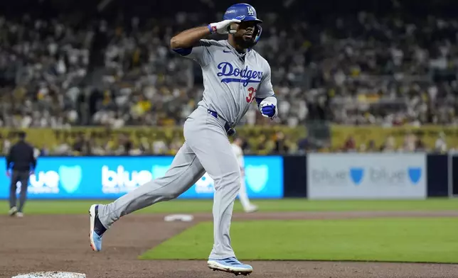 Los Angeles Dodgers' Teoscar Hernández reacts as he rounds third base after his grand slam during the third inning in Game 3 of a baseball NL Division Series against the San Diego Padres, Tuesday, Oct. 8, 2024, in San Diego. (AP Photo/Gregory Bull)