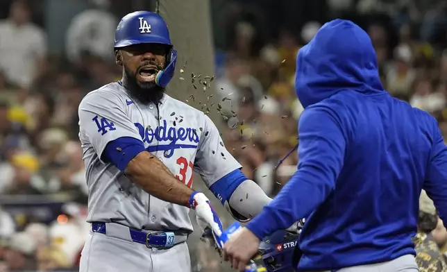 Los Angeles Dodgers' Teoscar Hernández gets sunflowers seeds to the face after hitting a grand slam during the third inning in Game 3 of a baseball NL Division Series against the San Diego Padres, Tuesday, Oct. 8, 2024, in San Diego. (AP Photo/Gregory Bull)