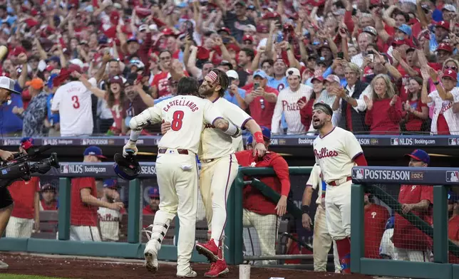 Philadelphia Phillies' Nick Castellanos (8) celebrates with Bryce Harper after hitting a home run against New York Mets pitcher Luis Severino during the sixth inning of Game 2 of a baseball NL Division Series, Sunday, Oct. 6, 2024, in Philadelphia. (AP Photo/Chris Szagola)