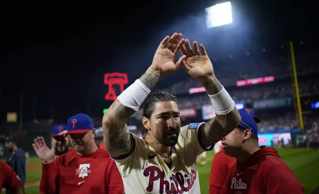 Philadelphia Phillies' Nick Castellanos celebrates his one-run single against New York Mets pitcher Tylor Megill during the ninth inning to win Game 2 of a baseball NL Division Series, Sunday, Oct. 6, 2024, in Philadelphia. (AP Photo/Matt Slocum)