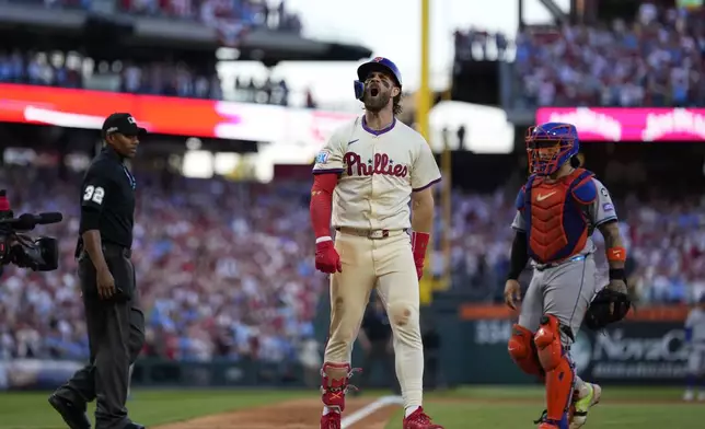 Philadelphia Phillies' Bryce Harper reacts after hitting a two-run home run against New York Mets pitcher Luis Severino during the sixth inning of Game 2 of a baseball NL Division Series, Sunday, Oct. 6, 2024, in Philadelphia. (AP Photo/Matt Slocum)