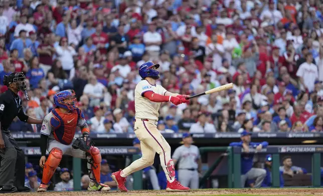 Philadelphia Phillies' Bryce Harper follow through after hitting a two-run home run against New York Mets pitcher Luis Severino during the sixth inning of Game 2 of a baseball NL Division Series, Sunday, Oct. 6, 2024, in Philadelphia. (AP Photo/Matt Slocum)