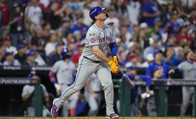 New York Mets' Pete Alonso follows the flight of the ball after hitting a run scoring sacrifice fly off Philadelphia Phillies pitcher Matt Strahm during the eighth inning of Game 1 of a baseball NL Division Series, Saturday, Oct. 5, 2024, in Philadelphia. (AP Photo/Matt Slocum)