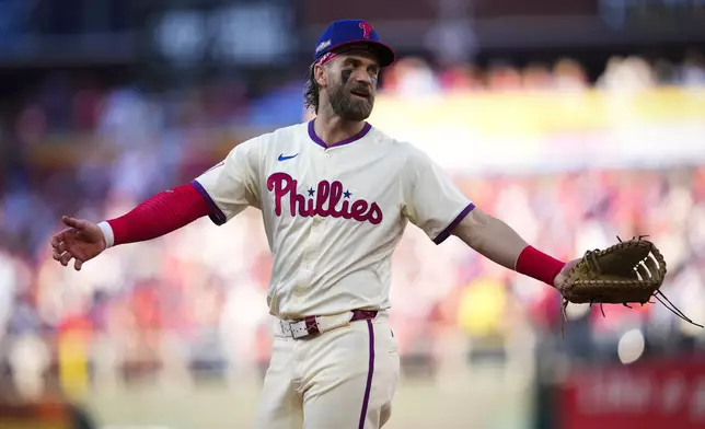 Philadelphia Phillies first base Bryce Harper talks with an umpire during the fourth inning of Game 1 of a baseball NL Division Series against the New York Mets, Saturday, Oct. 5, 2024, in Philadelphia. (AP Photo/Matt Slocum)