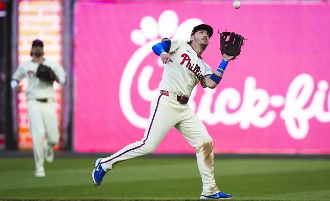 Philadelphia Phillies second base Bryson Stott catches a fly out hit by New York Mets' Jose Iglesias during the seventh inning of Game 1 of a baseball NL Division Series, Saturday, Oct. 5, 2024, in Philadelphia. (AP Photo/Chris Szagola)