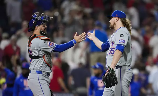 New York Mets' Ryne Stanek, right, and Luis Torrens celebrate after they won Game 1 of a baseball NL Division Series against the Philadelphia Phillies, Saturday, Oct. 5, 2024, in Philadelphia. (AP Photo/Matt Slocum)