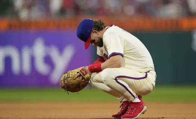 Philadelphia Phillies first base Bryce Harper rests during a pitching change during the eighth inning of Game 1 of a baseball NL Division Series against the New York Mets, Saturday, Oct. 5, 2024, in Philadelphia. (AP Photo/Matt Slocum)