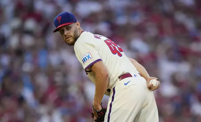 Philadelphia Phillies pitcher Zack Wheeler checks the runner at first during the seventh inning of Game 1 of a baseball NL Division Series against the New York Mets, Saturday, Oct. 5, 2024, in Philadelphia. (AP Photo/Matt Slocum)