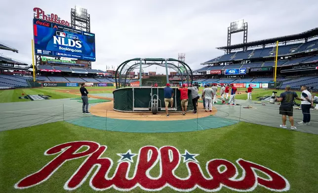 Philadelphia Phillies gather around the batting cage during a baseball workout, Friday, Oct. 4, 2024, in Philadelphia, ahead of the National League Division Series against the New York Mets. (AP Photo/Chris Szagola)