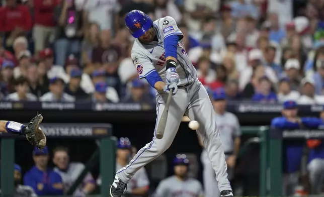 New York Mets' J.D. Martinez hits an RBI single off Philadelphia Phillies pitcher Orion Kerkering during the eighth inning of Game 1 of a baseball NL Division Series, Saturday, Oct. 5, 2024, in Philadelphia. (AP Photo/Matt Slocum)