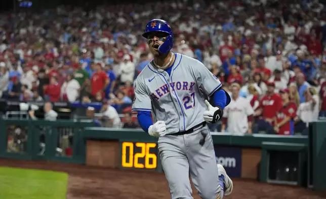 New York Mets' Mark Vientos celebrates hitting a two-run home run against Philadelphia Phillies pitcher Matt Strahm during the ninth inning of Game 2 of a baseball NL Division Series, Sunday, Oct. 6, 2024, in Philadelphia. (AP Photo/Chris Szagola)