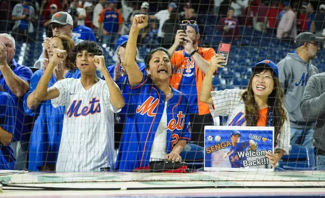 New York Mets fans celebrate after the Mets won Game 1 of a baseball NL Division Series against the Philadelphia Phillies, Saturday, Oct. 5, 2024, in Philadelphia. (AP Photo/Chris Szagola)