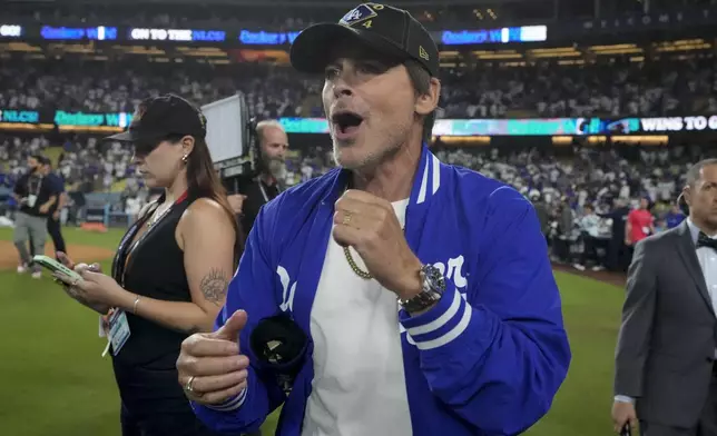 Actor Rob Lowe celebrates on the field after the Los Angeles Dodgers beat the San Diego Padres in Game 5 of a baseball NL Division Series Friday, Oct. 11, 2024, in Los Angeles. (AP Photo/Mark J. Terrill)