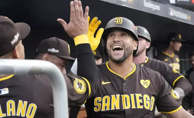 San Diego Padres' David Peralta celebrates in the dugout after hitting a two-run home run during the second inning in Game 2 of a baseball NL Division Series against the Los Angeles Dodgers, Sunday, Oct. 6, 2024, in Los Angeles. (AP Photo/Mark J. Terrill)