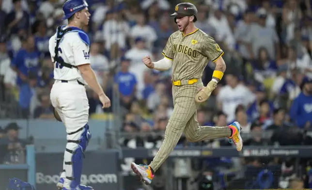 San Diego Padres' Jackson Merrill, right, celebrates as he scores as Los Angeles Dodgers catcher Will Smith, left, reacts during the third inning in Game 1 of baseball's NL Division Series, Saturday, Oct. 5, 2024, in Los Angeles. (AP Photo/Mark J. Terrill)