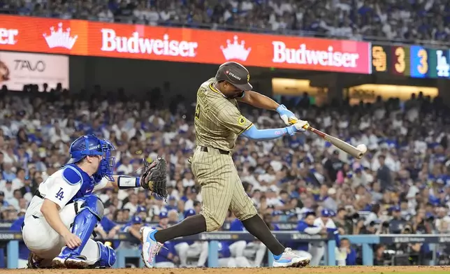 San Diego Padres' Xander Bogaerts, right, hits a two-run double in front of Los Angeles Dodgers catcher Will Smith, left, during the third inning in Game 1 of baseball's NL Division Series, Saturday, Oct. 5, 2024, in Los Angeles. (AP Photo/Mark J. Terrill)