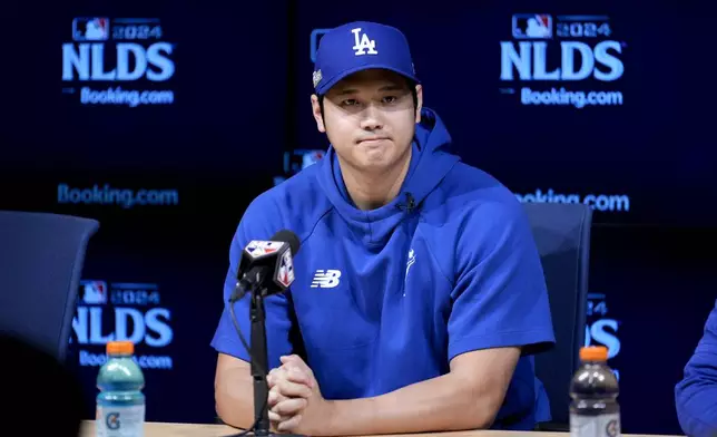 Los Angeles Dodgers' Shohei Ohtani fields questions ahead of Game 5 of a baseball National League Division Series against the San Diego Padres, Thursday, Oct. 10, 2024, in Los Angeles. (AP Photo/Ashley Landis)