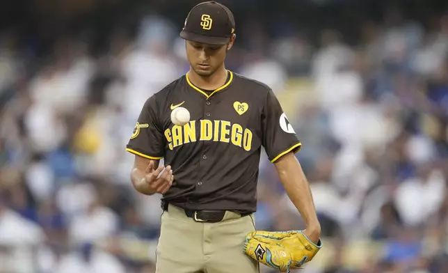 San Diego Padres pitcher Yu Darvish juggles the baseball on the mound during the fourth inning in Game 5 of a baseball NL Division Series against the Los Angeles Dodgers, Friday, Oct. 11, 2024, in Los Angeles. (AP Photo/Ashley Landis)