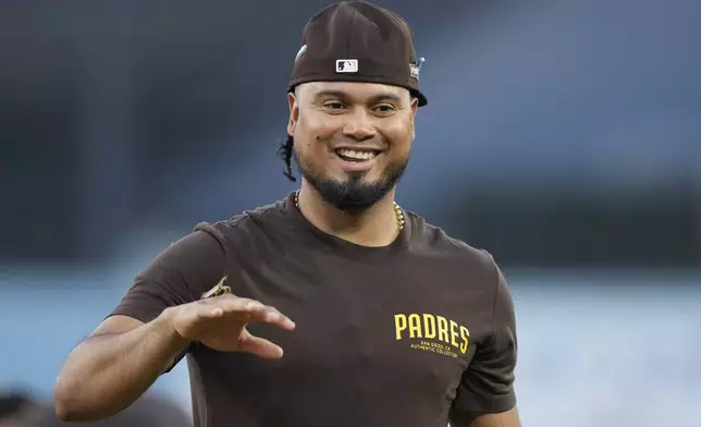 San Diego Padres' Luis Arraez has a praying mantis on his hand during practice ahead of Game 5 of a baseball National League Division Series against the Los Angeles Dodgers, Thursday, Oct. 10, 2024, in Los Angeles. (AP Photo/Ashley Landis)