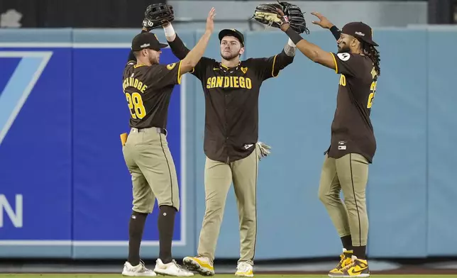 San Diego Padres outfielders Brandon Lockridge, left, Jackson Merrill, center, and Fernando Tatis Jr. celebrate after a win over the Los Angeles Dodgers in Game 2 of a baseball NL Division Series, Sunday, Oct. 6, 2024, in Los Angeles. (AP Photo/Mark J. Terrill)