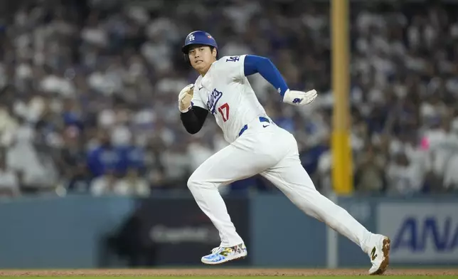 Los Angeles Dodgers' Shohei Ohtani runs from second to third base during the fourth inning in Game 1 of baseball's NL Division Series against the San Diego Padres, Saturday, Oct. 5, 2024, in Los Angeles. (AP Photo/Mark J. Terrill)