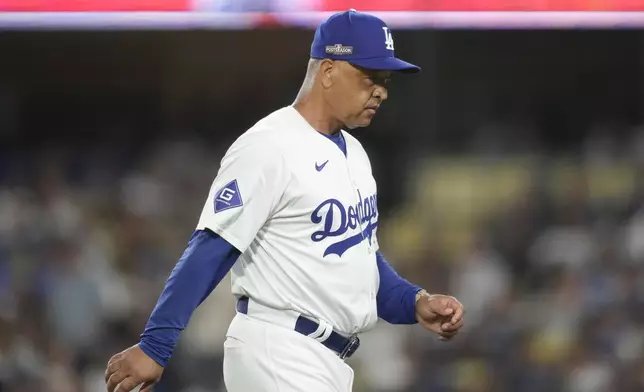 Los Angeles Dodgers manager Dave Roberts walks back to the dugout after making a pitching change during the seventh inning in Game 2 of a baseball NL Division Series against the San Diego Padres, Sunday, Oct. 6, 2024, in Los Angeles. (AP Photo/Ashley Landis)