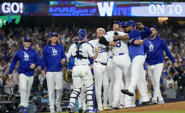 The Los Angeles Dodgers celebrate off the mound after defeating the San Diego Padres in Game 5 of a baseball NL Division Series Friday, Oct. 11, 2024, in Los Angeles. (AP Photo/Mark J. Terrill)