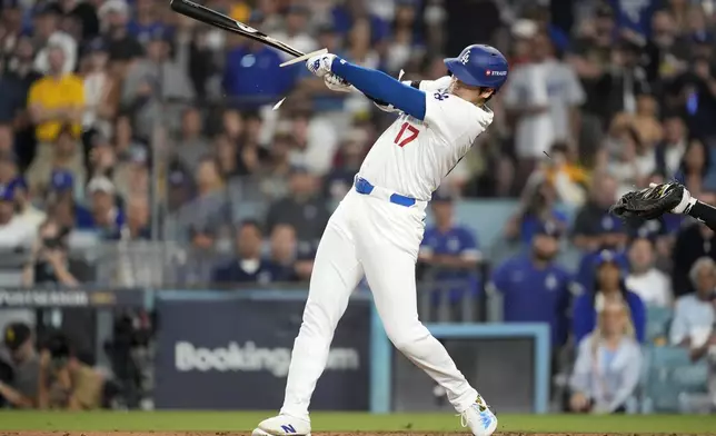 Los Angeles Dodgers' Shohei Ohtani breaks his bat as he singles during the fourth inning in Game 1 of baseball's NL Division Series against the San Diego Padres, Saturday, Oct. 5, 2024, in Los Angeles. (AP Photo/Ashley Landis)