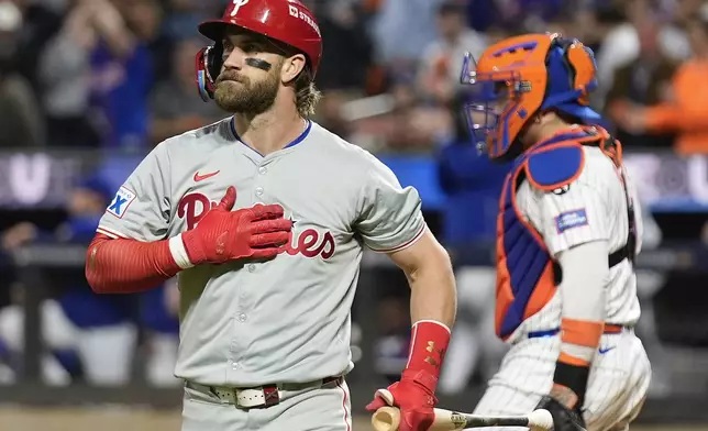 Philadelphia Phillies' Bryce Harper (3) reacts after striking out against the New York Mets during the sixth inning of Game 3 of the National League baseball playoff series, Tuesday, Oct. 8, 2024, in New York. (AP Photo/Seth Wenig)