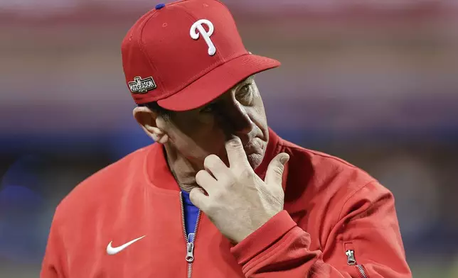 Philadelphia Phillies manager Rob Thomson walks off the field after a pitching change during the sixth inning of Game 4 of the National League baseball playoff series against the New York Mets, Wednesday, Oct. 9, 2024, in New York. (AP Photo/Adam Hunger)