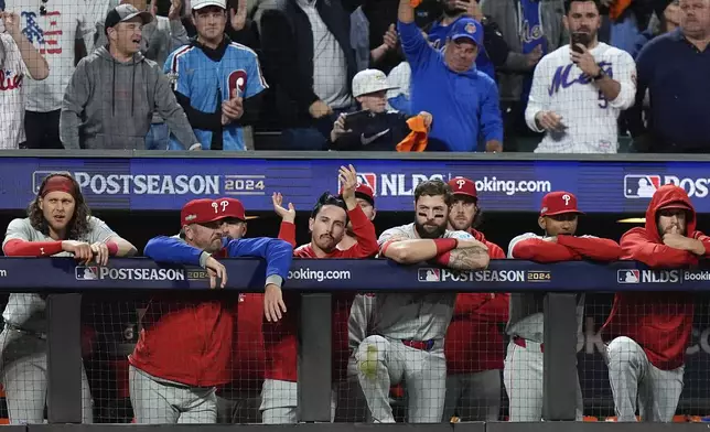 The Philadelphia Phillies watch play against the New York Mets in the ninth inning of Game 4 of the National League baseball playoff series, Wednesday, Oct. 9, 2024, in New York. (AP Photo/Frank Franklin II)