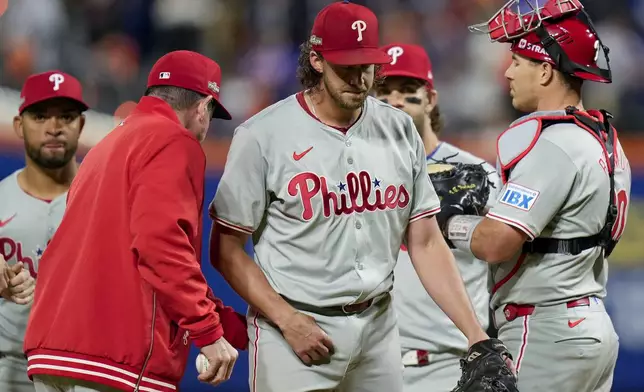 Philadelphia Phillies pitcher Aaron Nola is relieved by manager Rob Thomson during the sixth inning of Game 3 of the National League baseball playoff series against the New York Mets, Tuesday, Oct. 8, 2024, in New York. (AP Photo/Seth Wenig)