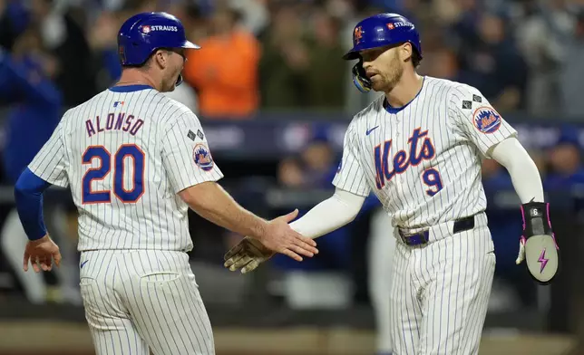 New York Mets' Pete Alonso (20) and Brandon Nimmo (9) celebrate after scoring on a base hit by Starling Marte against the Philadelphia Phillies during the sixth inning of Game 3 of the National League baseball playoff series, Tuesday, Oct. 8, 2024, in New York. (AP Photo/Seth Wenig)