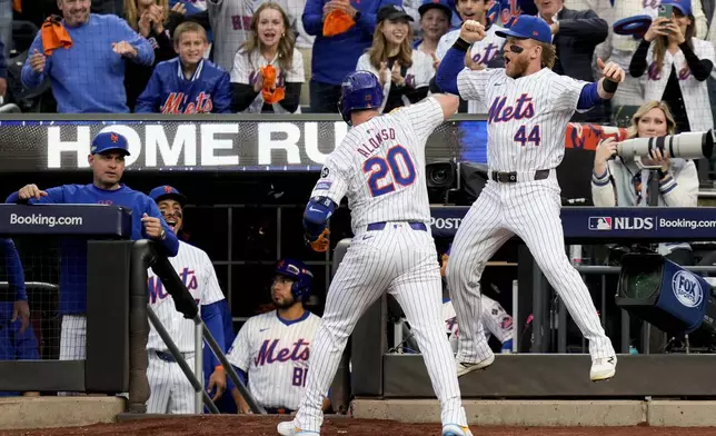 New York Mets' Pete Alonso (20) celebrates with Harrison Bader (44) after hitting a solo home run against the Philadelphia Phillies during the second inning of Game 3 of the National League baseball playoff series, Tuesday, Oct. 8, 2024, in New York. (AP Photo/Seth Wenig)