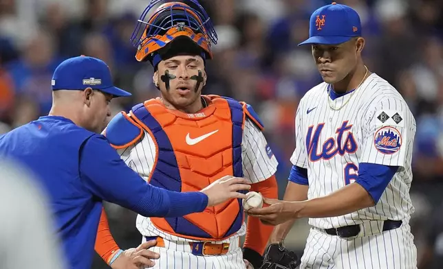 New York Mets pitcher Jose Quintana (62) hands the ball to manager Carlos Mendoza as he leaves the game during the sixth inning of Game 4 of the National League baseball playoff series against the Philadelphia Phillies, Wednesday, Oct. 9, 2024, in New York. (AP Photo/Frank Franklin II)