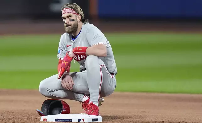 Philadelphia Phillies first baseman Bryce Harper (3) takes a break during a pitching change by the New York Mets during the sixth inning of Game 4 of the National League baseball playoff series, Wednesday, Oct. 9, 2024, in New York. (AP Photo/Frank Franklin II)