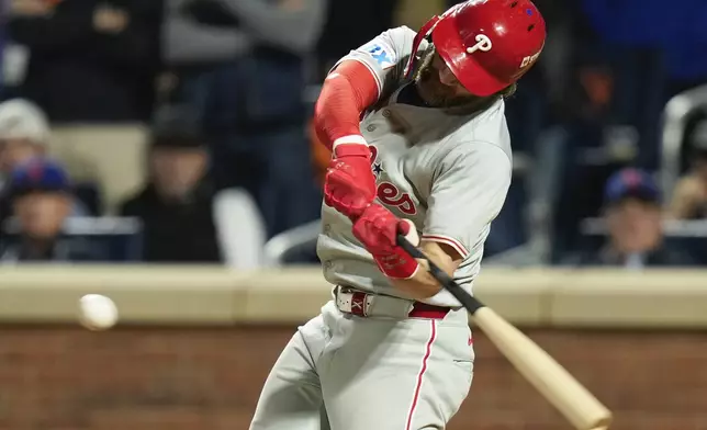 Philadelphia Phillies' Trea Turner (7) connects for an RBI single against the New York Mets during the eighth inning of Game 3 of the National League baseball playoff series, Tuesday, Oct. 8, 2024, in New York. (AP Photo/Seth Wenig)