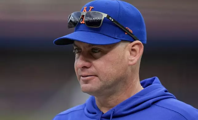 New York Mets manager Carlos Mendoza watches batting practice before Game 3 of the National League baseball playoff series against the Philadelphia Phillies, Tuesday, Oct. 8, 2024, in New York. (AP Photo/Frank Franklin II)