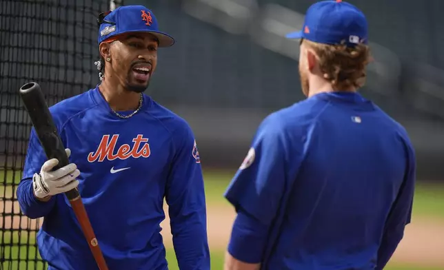 New York Mets shortstop Francisco Lindor talks to outfielder Harrison Bader during batting practice before playing against the Philadelphia Phillies in Game 3 of the National League baseball playoff series, Tuesday, Oct. 8, 2024, in New York. (AP Photo/Frank Franklin II)