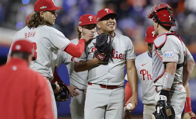 Philadelphia Phillies pitcher Ranger Suárez, center, reacts as he waits to be relieved during the fifth inning of Game 4 of the National League baseball playoff series against the New York Mets, Wednesday, Oct. 9, 2024, in New York. (AP Photo/Adam Hunger)