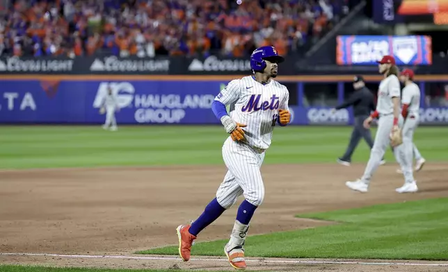 New York Mets shortstop Francisco Lindor (12) rounds the bases after hitting a grand slam home run against the Philadelphia Phillies during the sixth inning of Game 4 of the National League baseball playoff series, Wednesday, Oct. 9, 2024, in New York. (AP Photo/Adam Hunger)