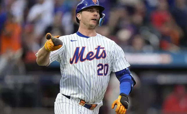 New York Mets' Pete Alonso (20) tosses his bat as he watches his solo home run sail over the right field wall against the Philadelphia Phillies during the second inning of Game 3 of the National League baseball playoff series, Tuesday, Oct. 8, 2024, in New York. (AP Photo/Frank Franklin II)