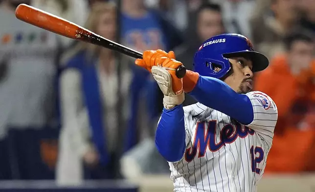 New York Mets' Francisco Lindor (12) follows through on a grand slam home run against the Philadelphia Phillies during the sixth inning of Game 4 of the National League baseball playoff series, Wednesday, Oct. 9, 2024, in New York. (AP Photo/Frank Franklin II)