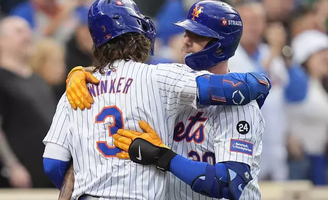 New York Mets' Pete Alonso (20) hugs Jesse Winker (3) after hitting a solo home run against the Philadelphia Phillies during the second inning of Game 3 of the National League baseball playoff series, Tuesday, Oct. 8, 2024, in New York. (AP Photo/Frank Franklin II)