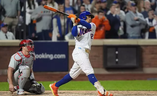 New York Mets' Francisco Lindor (12) follows through on a grand slam home run against the Philadelphia Phillies during the sixth inning of Game 4 of the National League baseball playoff series, Wednesday, Oct. 9, 2024, in New York. (AP Photo/Frank Franklin II)