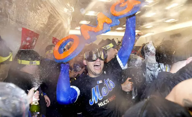 The New York Mets celebrate in the locker room after defeating the Philadelphia Phillies in Game 4 of the National League baseball playoff series, Wednesday, Oct. 9, 2024, in New York. (AP Photo/Frank Franklin II)