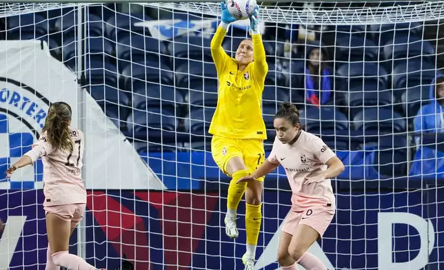 Angel City FC goalkeeper DiDi Haracic collects the ball as defender Madison Curry (27) and defender Megan Reid, right, look on during the second half of an NWSL soccer match against the Seattle Reign, Friday, Oct. 4, 2024, in Seattle. Angel City won 1-0. (AP Photo/Lindsey Wasson)