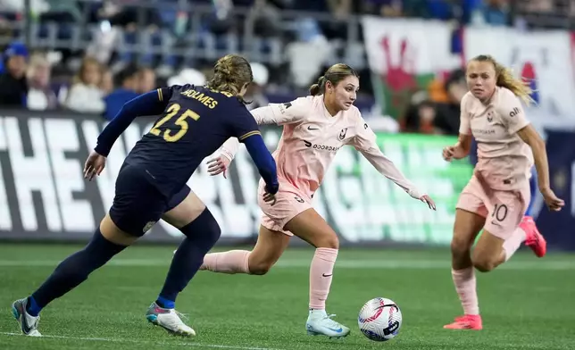 Angel City FC defender Gisele Thompson moves the ball against Seattle Reign defender Shae Holmes (25) during the second half of an NWSL soccer match Friday, Oct. 4, 2024, in Seattle. Angel City won 1-0. (AP Photo/Lindsey Wasson)